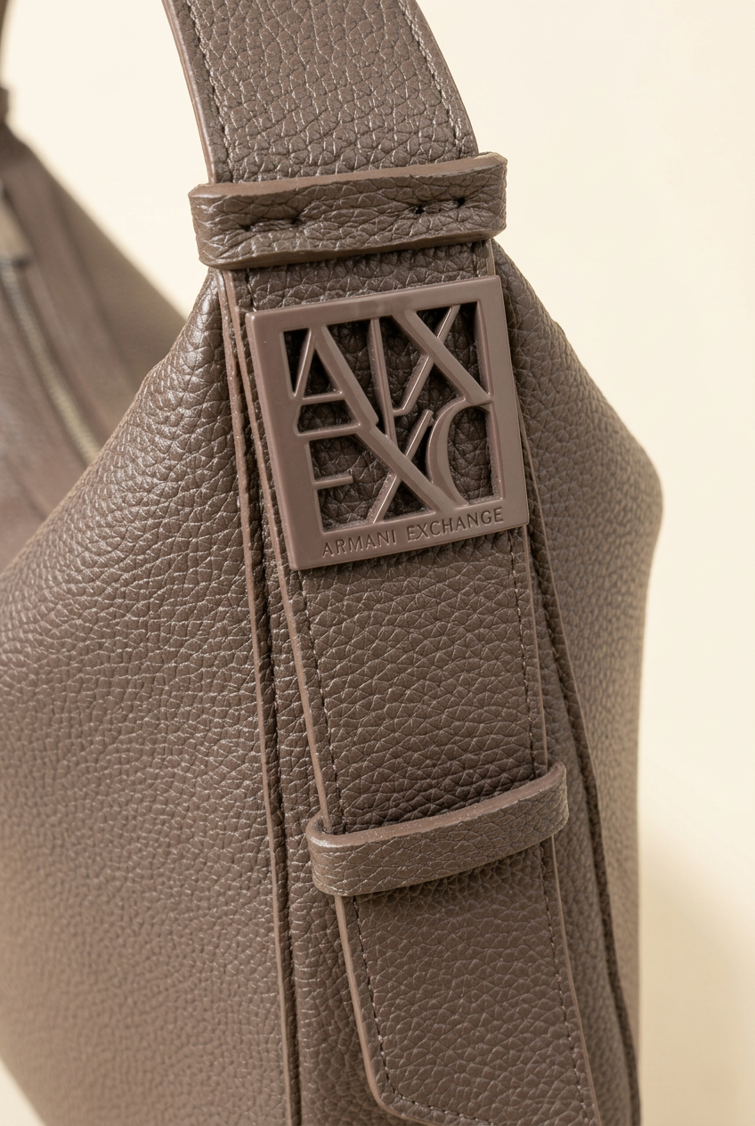 Dettaglio della borsa Armani Exchange su sfondo chiaro